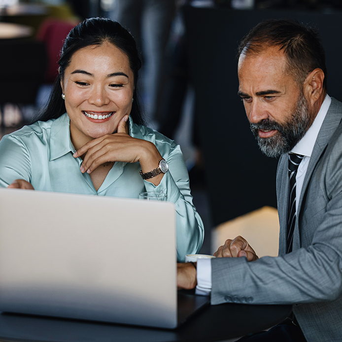 Two professionals discussing about the data on the laptop